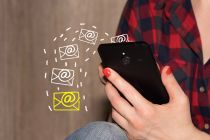 Foto: Frau hält Mobiltelefon in der Hand