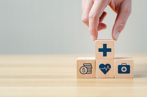 Foto: Hand legt einen Holzblock auf andere Blöcke