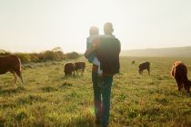 Foto:  Mädchen und Vater spazieren über ein Feld